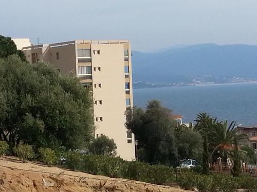 a tall white building next to the water at F2 Le Lavezzi in Ajaccio