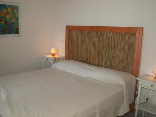 a bedroom with a bed and two tables with candles at VILLETTA SUL MARE, PANORAMICA in Villaputzu