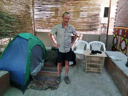 a man standing in front of a tent at david hostel in Aswan