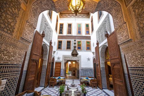 a hallway in a building with a chandelier at Riad Sidrat Fes in Fès