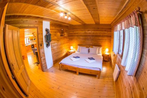 a bedroom with a bed in a wooden cabin at Elsa Chalupa in Kunvald