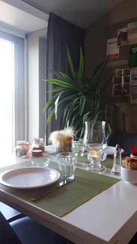 a table with a plate and bowls and a plant at Bed & Breakfast El Manso in Emst
