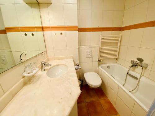 ein Badezimmer mit einem Waschbecken, einem WC und einer Badewanne in der Unterkunft Residenz Bleichröder - Ferienwohnung 16 in Heringsdorf