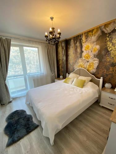 ein Schlafzimmer mit einem großen Bett und einer Blumenwand in der Unterkunft Harmony apartment Sinaia in Sinaia