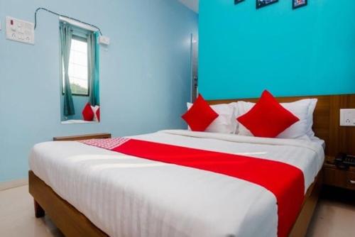 a bedroom with a large bed with red pillows at HOTEL SHIVRAI in Pen