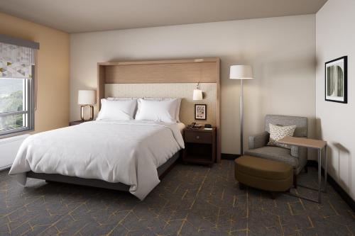 a hotel room with a large bed and a chair at Holiday Inn - Long Island - ISLIP Arpt East, an IHG Hotel in Holtsville