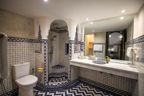 a bathroom with a shower and a toilet and a sink at Riad Sidrat Fes in Fez