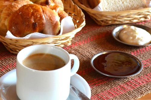 a cup of coffee and a basket of bread at Hostería Güemes in San Carlos de Bariloche