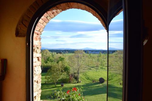an arched window with a view of a field at Monastero San Silvestro in Cortona