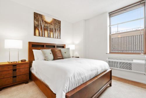 a bedroom with a large bed and a window at Global Luxury Suites at Hoboken Waterfront in Hoboken