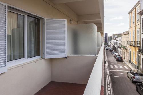 a balcony of a building with windows and a street at Hotel Sete Cidades in Ponta Delgada