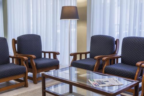 a waiting room with three chairs and a coffee table at Hotel Sete Cidades in Ponta Delgada