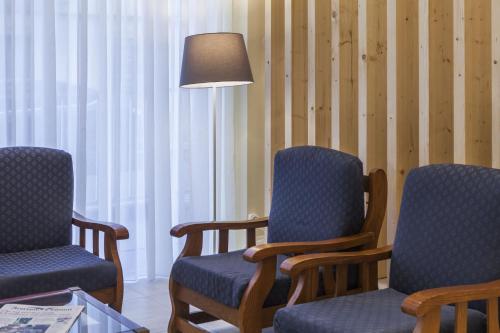 a waiting room with two chairs and a lamp at Hotel Sete Cidades in Ponta Delgada