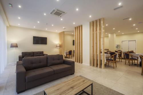 a living room with a couch and a dining room at Hotel Sete Cidades in Ponta Delgada
