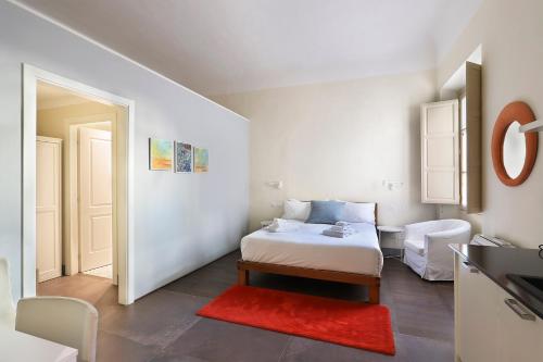 a small bedroom with a bed and a red rug at Apt. Perla - Pauline Suites, Palazzo Borghese in Florence