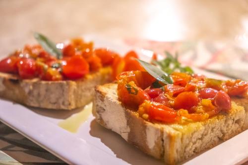 two pieces of bread with tomatoes on top on a plate at Refúgios Parajuru - Villa Cristiano in Parajuru