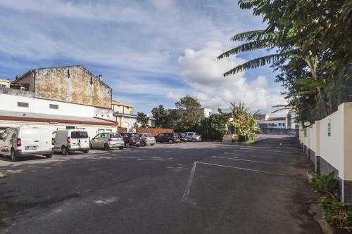 an empty street with cars parked in a parking lot at Hotel Sete Cidades in Ponta Delgada
