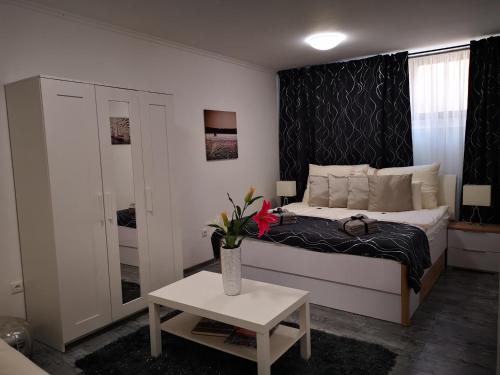 1 dormitorio con 1 cama y un jarrón de flores sobre una mesa en Luxury Basement in the surrounding of Budapest, en Mogyoród