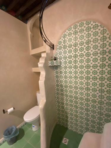 a small bathroom with a toilet and a shower at Casa Perleta in Chefchaouene