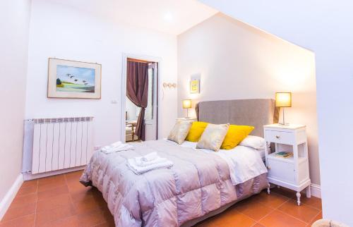 1 dormitorio con 1 cama con almohadas amarillas en Siqillya Etna, en Linguaglossa
