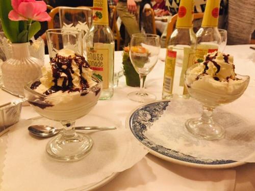 two ice cream sundas on a table with wine bottles at Hotel Eleon in Bad Teinach-Zavelstein
