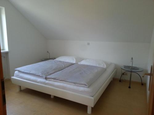 a white bed in a room with a table at Appartement Feldkirch in Feldkirch