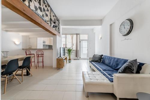 un salon avec un canapé bleu et une cuisine dans l'établissement Le Saint Clair par Dodo-a-Cassis, à Cassis