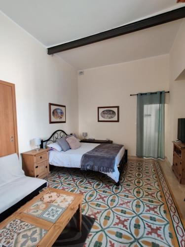 sypialnia z łóżkiem i stołem w obiekcie Ellas Place w mieście Tarxien