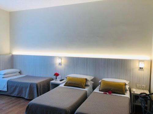 a hospital room with two beds and flowers on top at Hotel La Nuova Rotaia in Gallarate