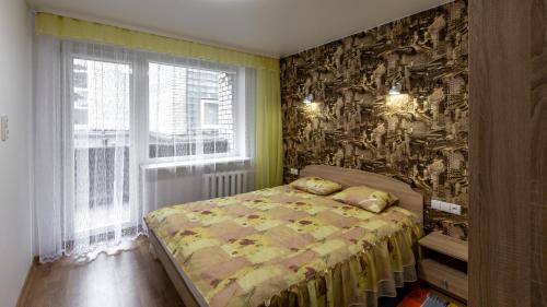 ein Schlafzimmer mit einem Bett und einem Wandbild in der Unterkunft Abariaus Apartamentai in Druskininkai