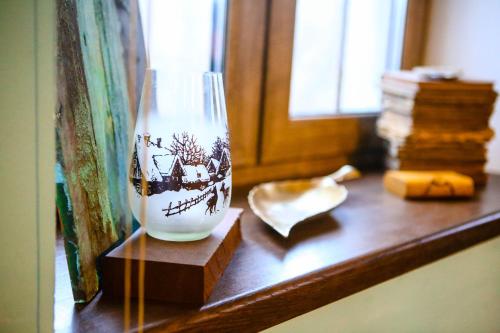 een vaas op een houten plank met een raam bij Sunrise Apartment in Kamjanets-Podilsky