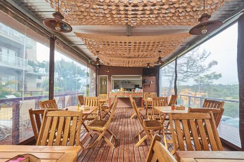 un restaurante con mesas de madera y sillas en una terraza en Punto Playa en Villa Gesell