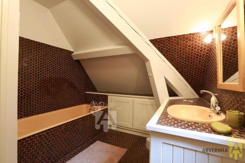 une salle de bain avec un lavabo et une baignoire dans l'établissement Villa Mayabell, à Besse-et-Saint-Anastaise