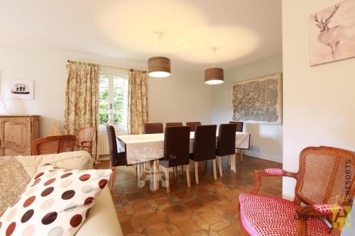 un salon avec une table et des chaises de salle à manger dans l'établissement Villa Mayabell, à Besse-et-Saint-Anastaise