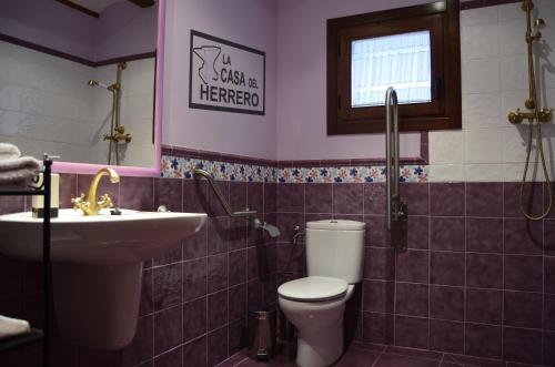 ein Badezimmer mit Toilette und Waschbecken in der Unterkunft La Casa del Herrero in El Poyo