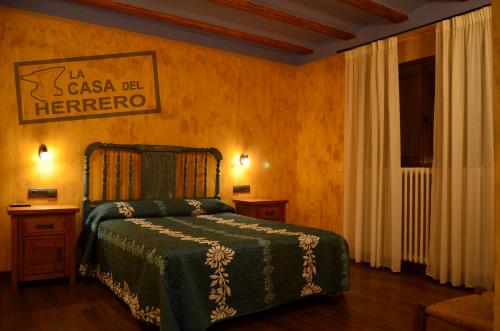 1 dormitorio con 1 cama y un cartel en la pared en La Casa del Herrero, en El Poyo