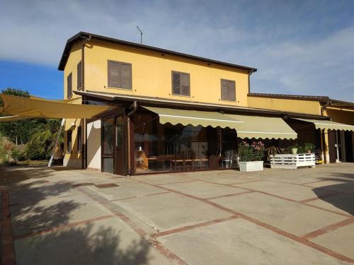 un edificio con una tienda con mesas y sillas en Giardino - Poggio del Casale - Affittacamere - landlords en San Cataldo