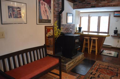 a living room with a bench and a stove at Mount Harmony Farm Guest House in Sheffield