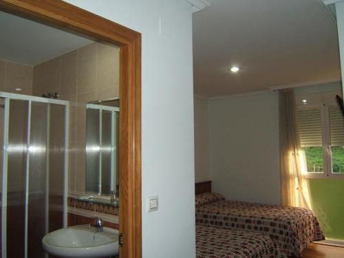 bagno con lavandino, letto e specchio di Hotel Severino a Ourense
