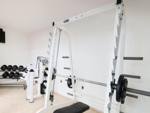 a gym with a squat rack and weights at Fraga Hotel Boutique in Irapuato