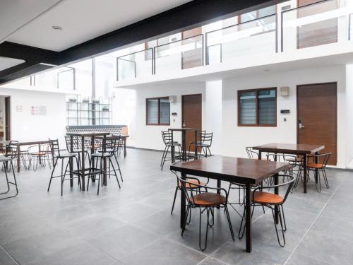 a room with tables and chairs and windows at Fraga Hotel Boutique in Irapuato