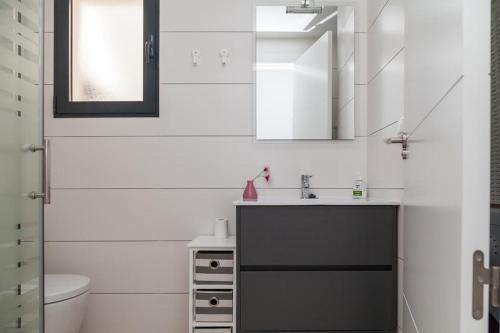 a white bathroom with a sink and a toilet at Apartament Puerto Romano, La Mata, close to the beach plus parking space in the underground garage in La Mata