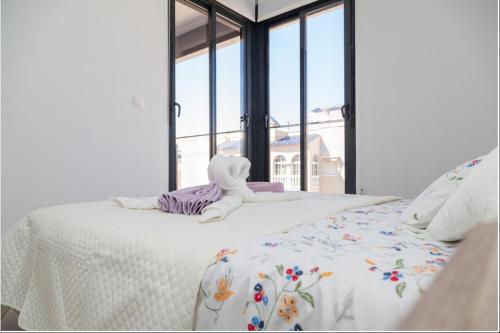 un lit blanc avec un animal rembourré au dessus dans l'établissement 003 Apartament Puerto Romano, à La Mata