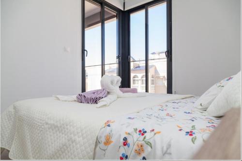 a white bed with a stuffed animal on top of it at Apartament Puerto Romano, La Mata, close to the beach plus parking space in the underground garage in La Mata