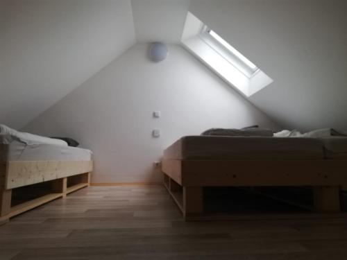 2 camas en una habitación con techo inclinado en Knusperhaus mit Garten, en Salzburgo