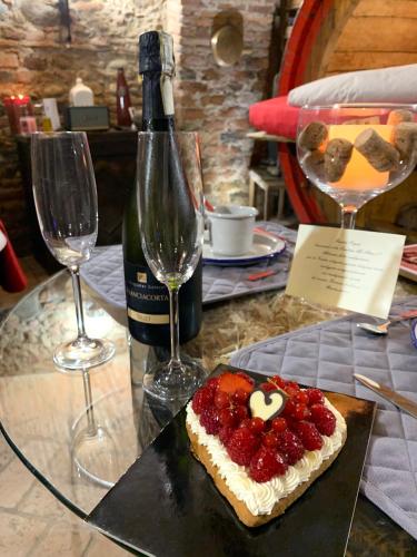 a cake with strawberries on a table with a bottle of wine at Al Silter in Capriate San Gervasio