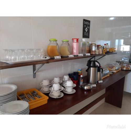 une cuisine avec un comptoir avec des assiettes et des tasses dans l'établissement Pousada Vitória, à Canindé de São Francisco