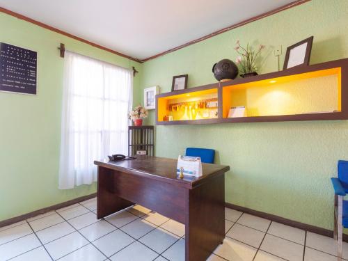 - un bureau avec un bureau en bois dans la chambre dans l'établissement Hotel Posada San Rafael, à Oaxaca