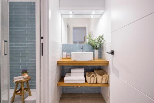 Łazienka wyłożona jest niebieskimi kafelkami i wyposażona w umywalkę. w obiekcie Apartamento Cádiz Centro Blue Window w Kadyksie