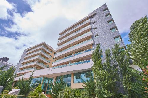 a tall building with trees in front of it at Albar Club de Mar in Pinamar
